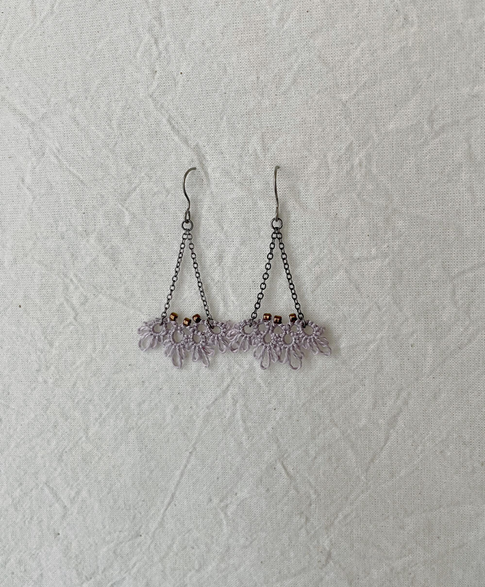 Earrings in DMC perle cotton #3042. Glass seed beads.